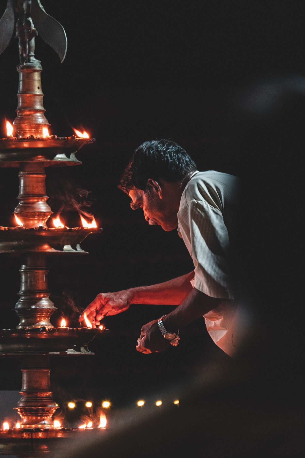 A devotee lights a lamp in a temple in Thrissur, Kerala
