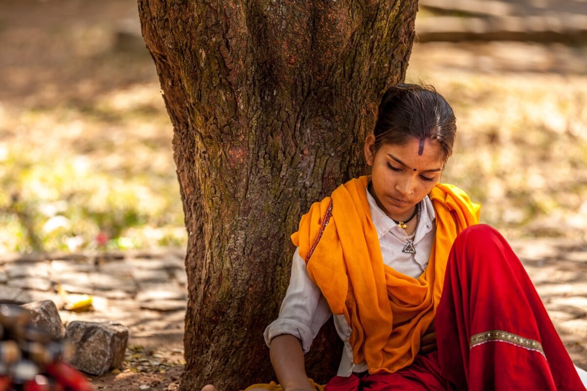 a lovely hindu girl rests under the shade of a tree